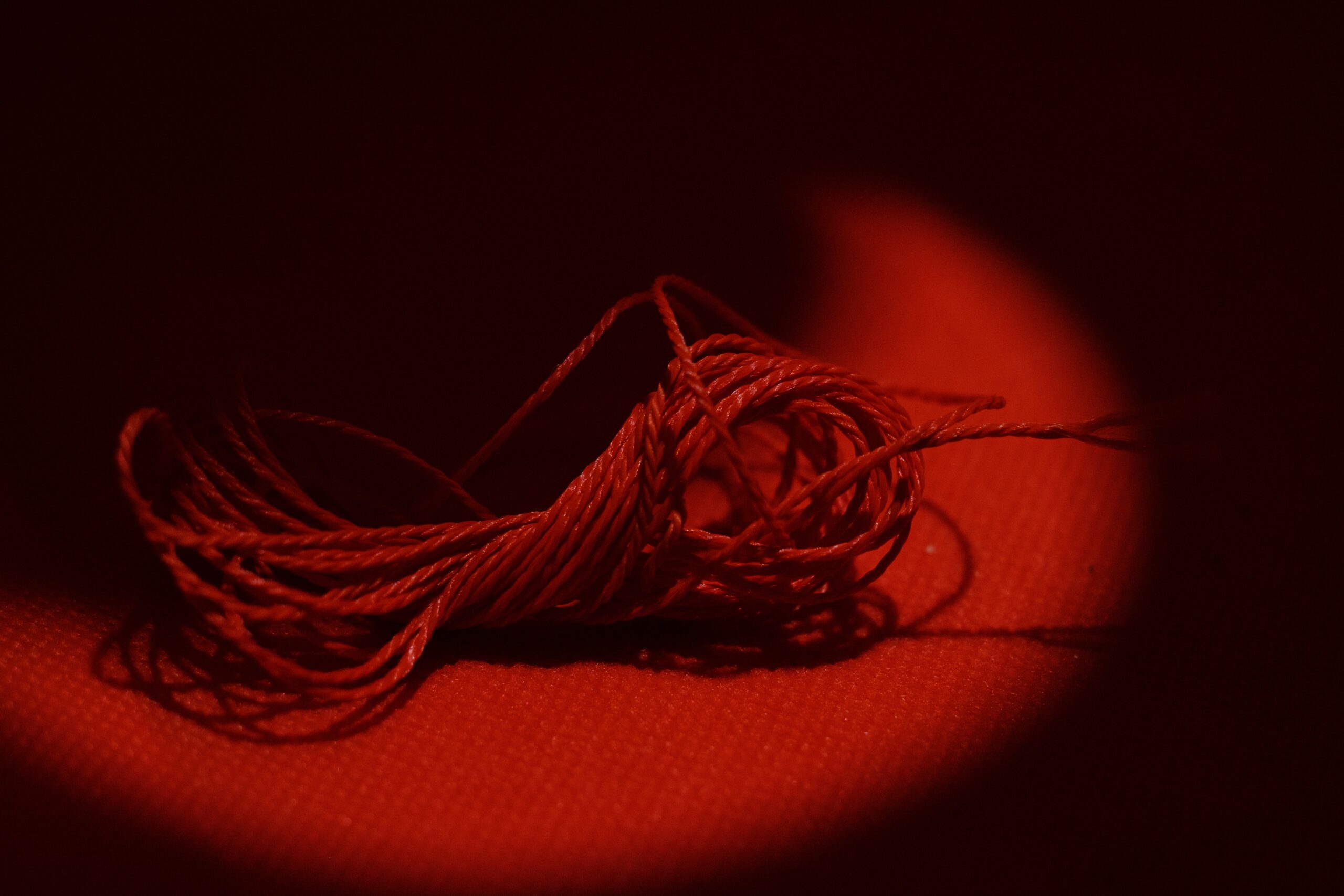 Red thread on black roma-kaiuk-xbAb8NY8NY4-unsplash